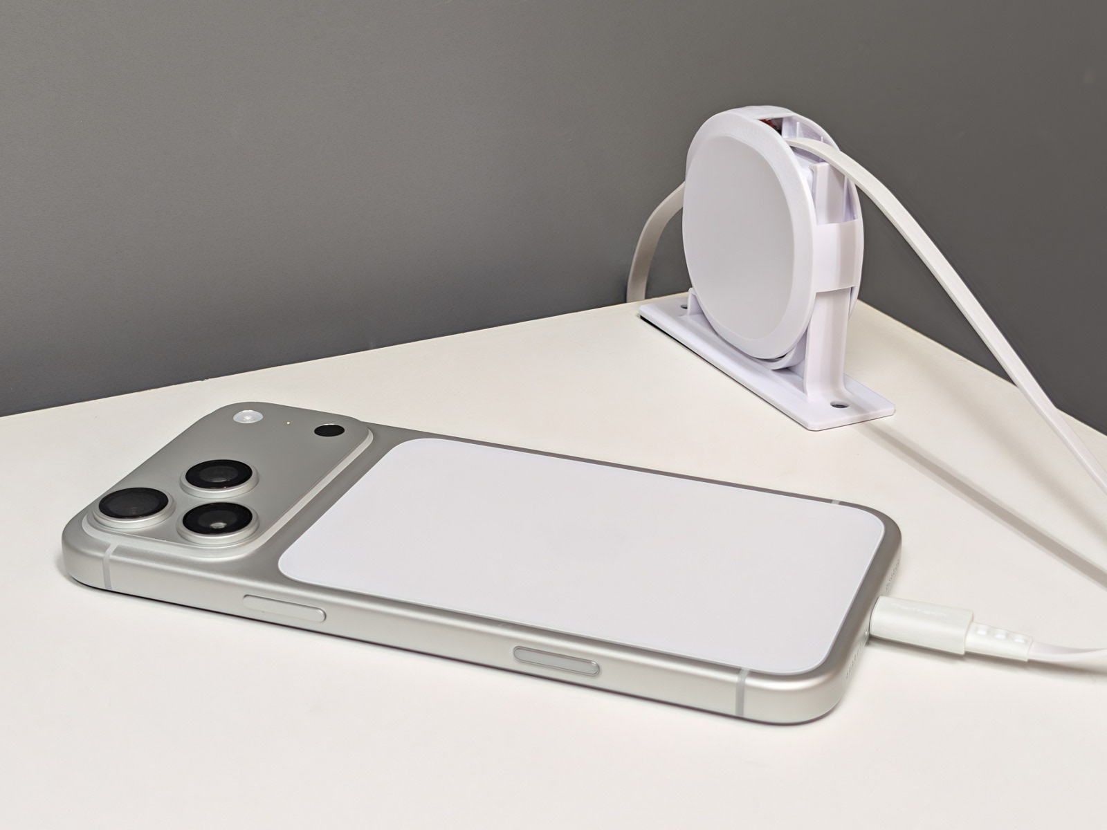 iPhoneを充電中。未使用時はケーブルを巻き取っておけるのでデスク上が乱雑にならない