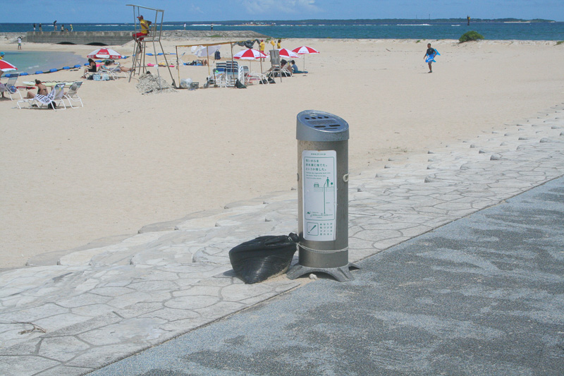 遊泳区域では海水浴を楽しんだり、デッキチェアやビーチパラソルでくつろいだりする人々が。灰皿も数mおきに設置されている