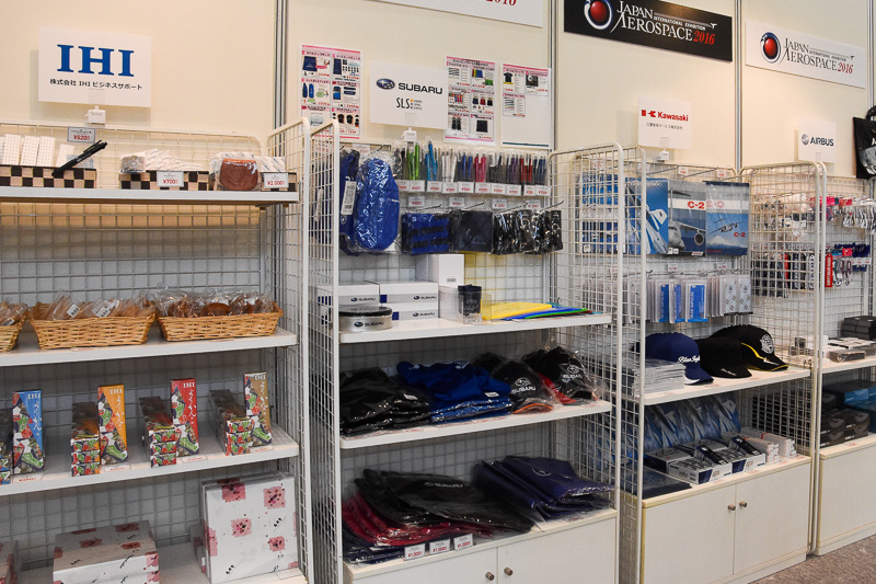 オフィシャルグッズショップ。MRJやエアバス、富士重工業（スバル）、川崎重工業、IHI、ベル・ヘリコプター、ビーシーシーの宇宙グッズの商品が並ぶ