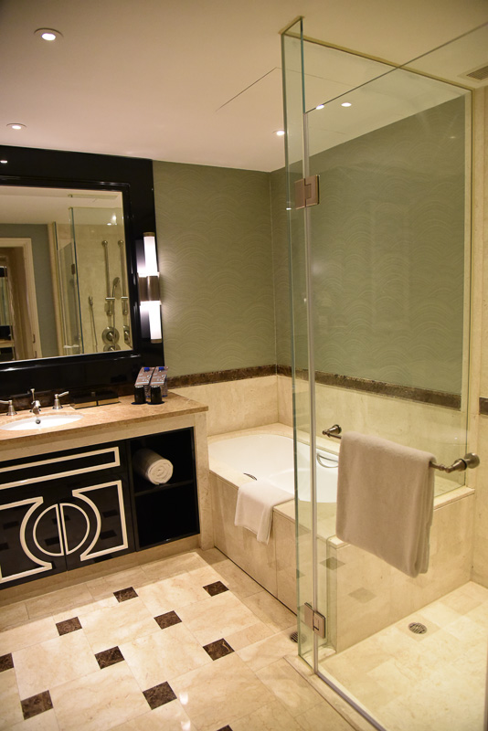 バスルームは大理石が採用され、かなり広々な空間。ガラス張りのウォークインシャワーとバスタブ