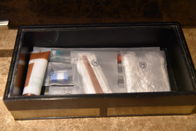 アメニティ類は洗面台のボックスの中。歯ブラシセットやボディーローションやシャワーキャップ、綿棒など一式が揃っている