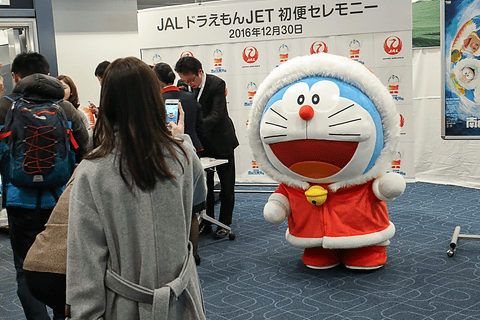 JAL ドラえもんJET」の国内線初便で、コート姿のドラえもんが出発