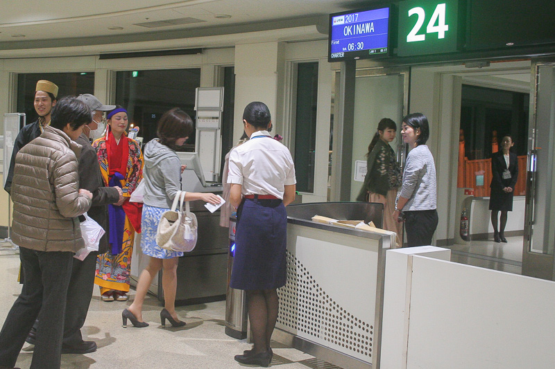 6時15分に搭乗開始。琉装のスタッフに見送られてツアー参加者がチャーター機へ向かう