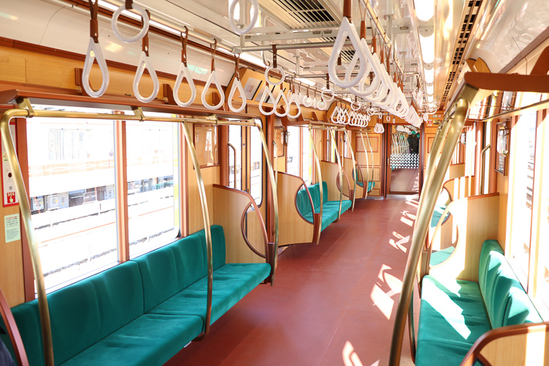 木目調のパネルと真鍮色や濃い赤の仕上げで室内からシルバーは極力排除