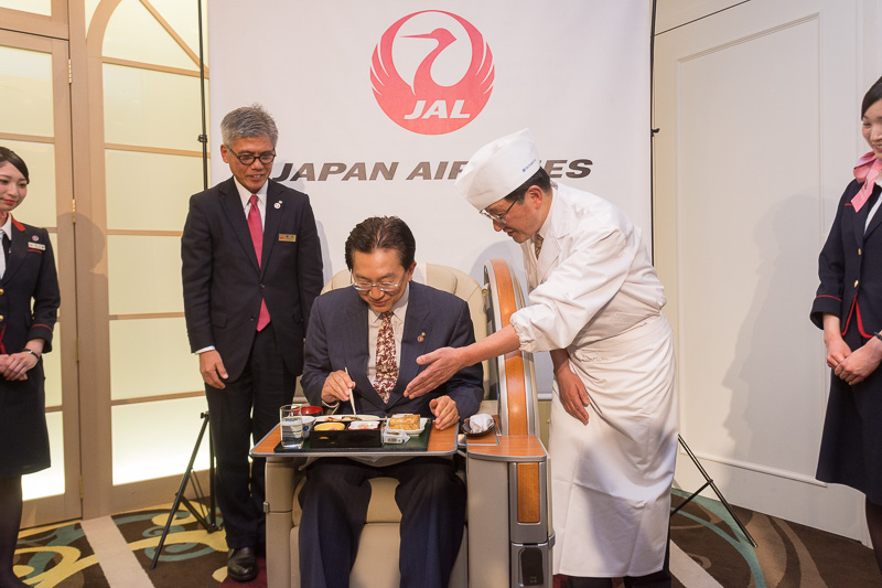 国内線ファーストクラスシートに座って2月上旬提供メニューを試食する岩手県知事の達増氏
