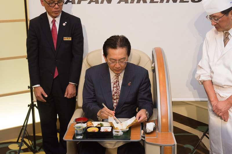 国内線ファーストクラスシートに座って2月上旬提供メニューを試食する岩手県知事の達増氏