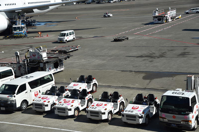 乗客にランプサービス部の業務や作業について解説。いつもはイエローの安全ベストだがイベント中は桜色のスペシャル版となっていた