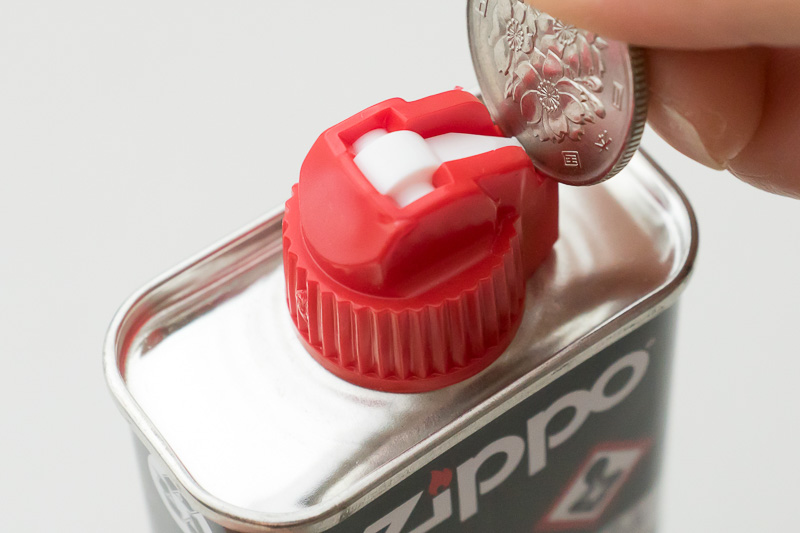 Zippoオイル缶の注入口にはコインが刺さるようになっている。ちょっとこじるようにして開ける