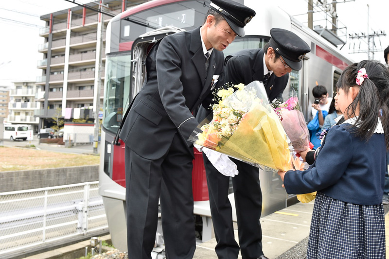 花束贈呈を受ける運転士と車掌