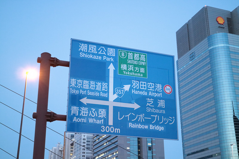 お台場中央交差点のかなり手前にある道路案内標識、首都高の緑色の案内部分は開通まで目隠しがされていた