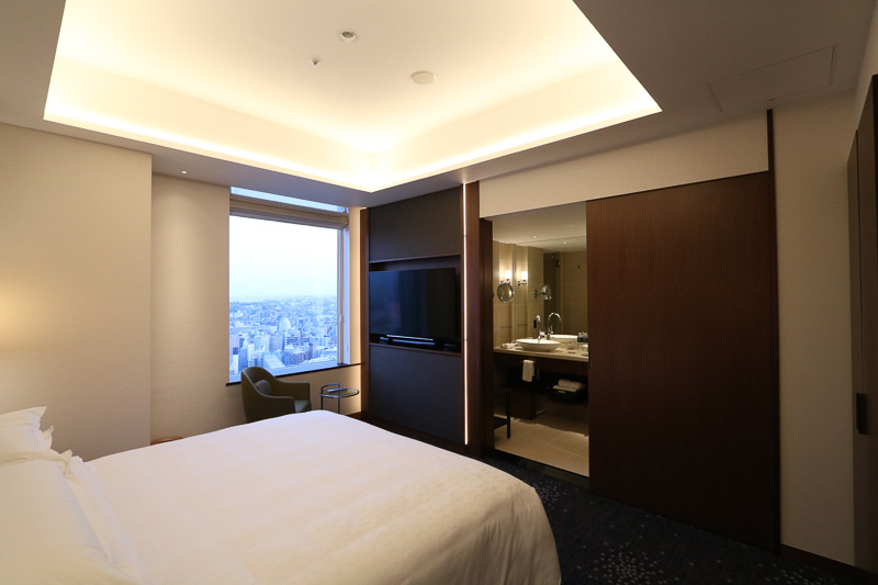 ベッドルームの先に洗面台やバスルームがある