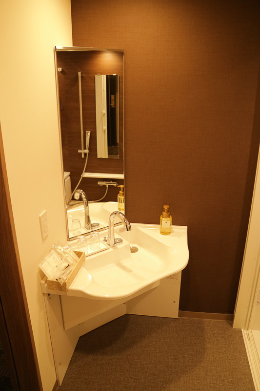 手すりを各所に設け、車いすでも洗面台に近付きやすいようになっている