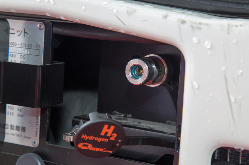 現状、FCフォークリフトへの水素充填はスタンドにいる専門のスタッフが行なう。といっても簡単、安全に充填できる操作系になっている。充填前は静電気除去シートにタッチ。ディスペンサーのホースの先端はチャック式になっていて、車体側のチャックの押し込むことでロックされる