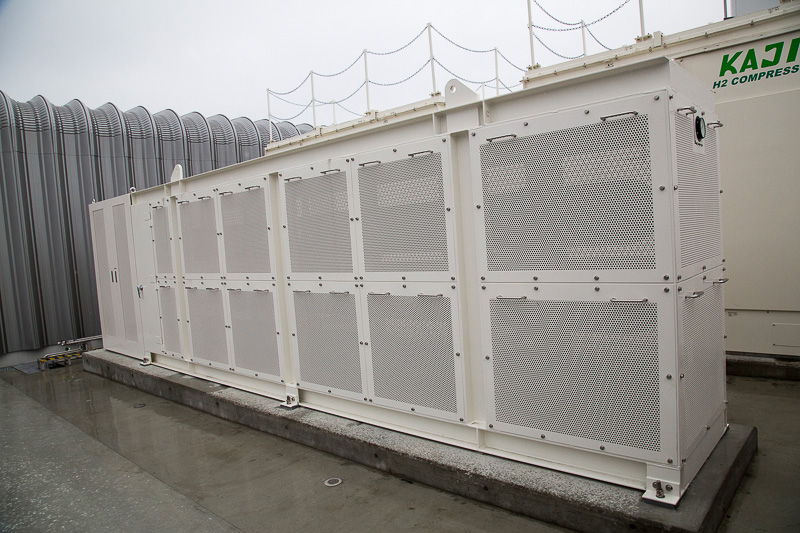 白い横長の装置が水素貯蔵用の蓄圧器。3本入っていて、高圧水素ディスペンサーで同時、連続充填も可能になっているとのこと