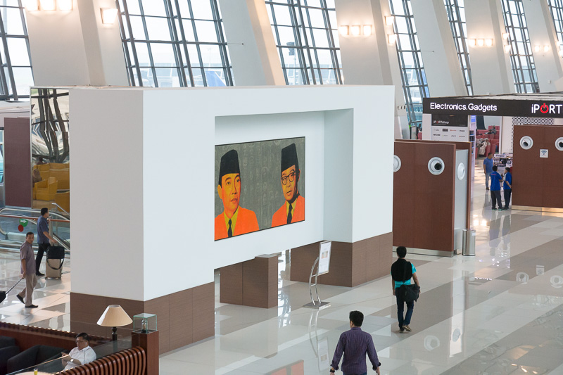 搭乗ロビーを上から。ゲートの間隔はわりと広く、ソファも十分に用意されている。空港の名前になっているオランダからの独立を牽引したインドネシア共和国初代大統領のスカルノ、初代副大統領のモハメド・ハッタの肖像画も飾られていた