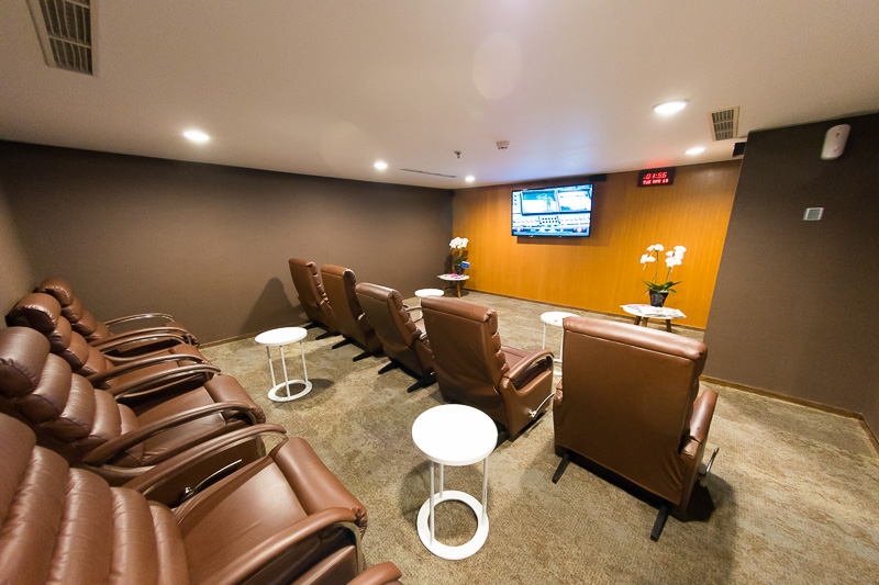 ビジネスラウンジ内のミニシアター。上映作品はラウンジ入り口とシアターの入り口に掲示。ディスプレイの脇に大きな時計がある