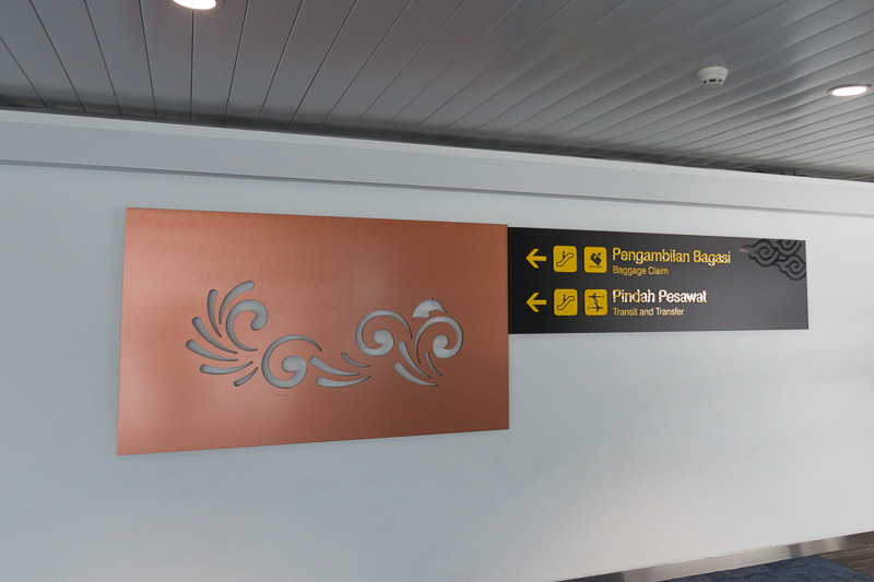 到着ロビーの預け入れ荷物の受取所へ。国際線乗り継ぎとしてターミナル2への移動の案内が残る