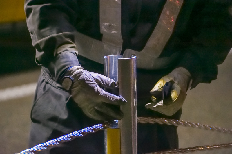 支柱のスリットにワイヤーと樹脂の部材を交互にはめていく