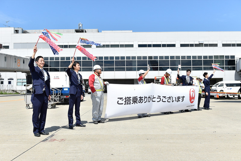 ミニこいのぼりを持ち手を振る男性スタッフ