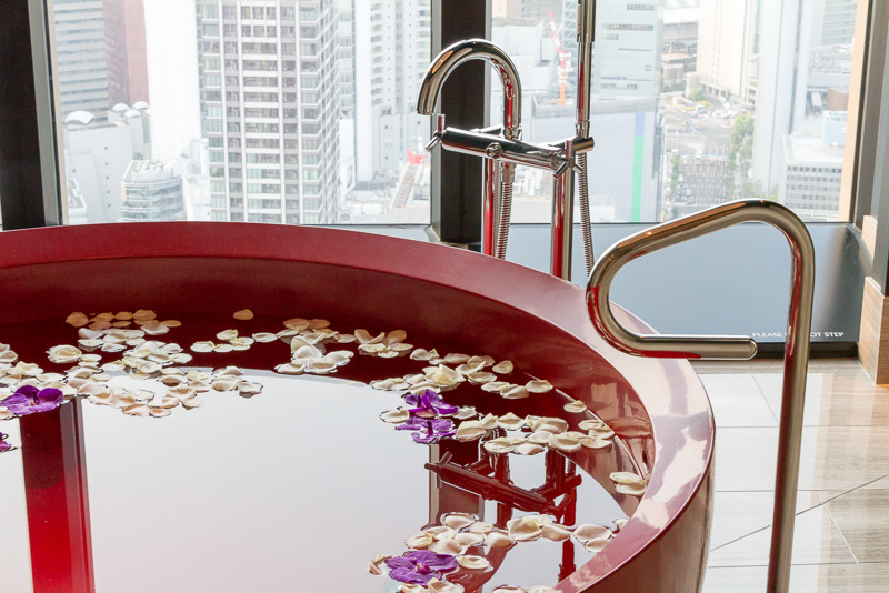 バスルームには漆塗りの真紅の浴槽があり、この部屋の特別感を醸し出している。すぐそばの窓からシティビューを眺めながら過ごすバスタイムは至福の時間を提供してくれることだろう