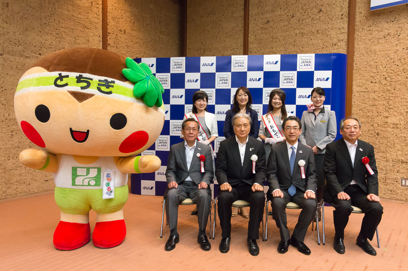 記者発表会に列席した関係者。前列左より公益社団法人 栃木県観光物産協会 会長 新井俊一氏、栃木県知事 福田富一氏、全日本空輸株式会社 代表取締役社長 平子裕志氏、栃木県酒造組合 会長 菊地正幸氏。後列左より、とちぎおもてなしメイツ 鎗田景子氏、全日本空輸株式会社 上席執行役員 菅谷とも子氏、とちぎおもてなしメイツ 日ヶ久保真依氏、ANA CA（客室乗務員）。左は栃木県マスコットキャラクターのとちまるくん
