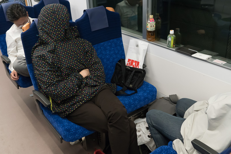 練馬駅から先は、車内の照明が暗くなった。真っ暗にはならないので、フードをかぶって仮眠している人も