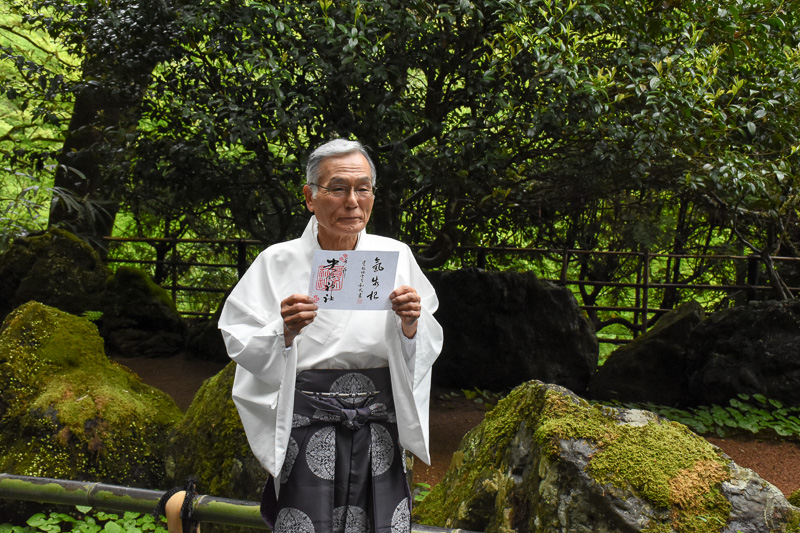 限定御朱印を手にする宮司 高井和大氏