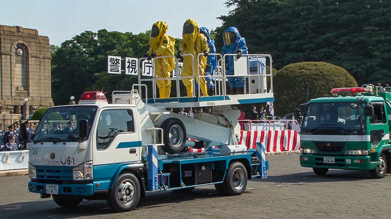 密閉式の化学防護服を着装して高所作業車に乗る隊員