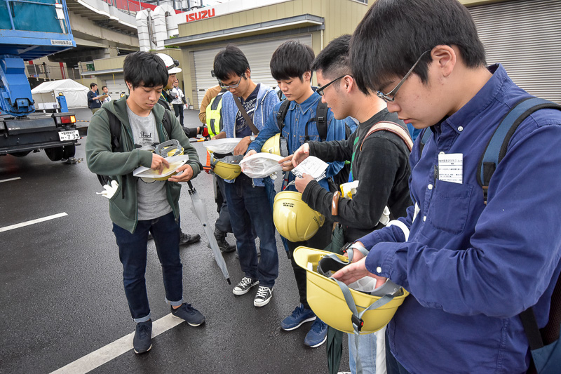 高所作業車に乗るということで、学生たちにヘルメットと安全帯が配布された