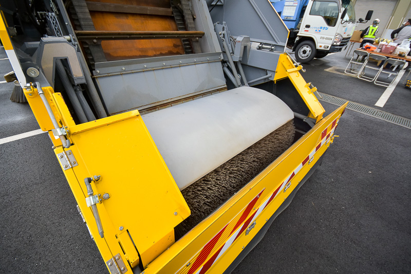 路面の清掃をする特殊清掃車。両脇のブラシは、路肩のゴミを掃き取る