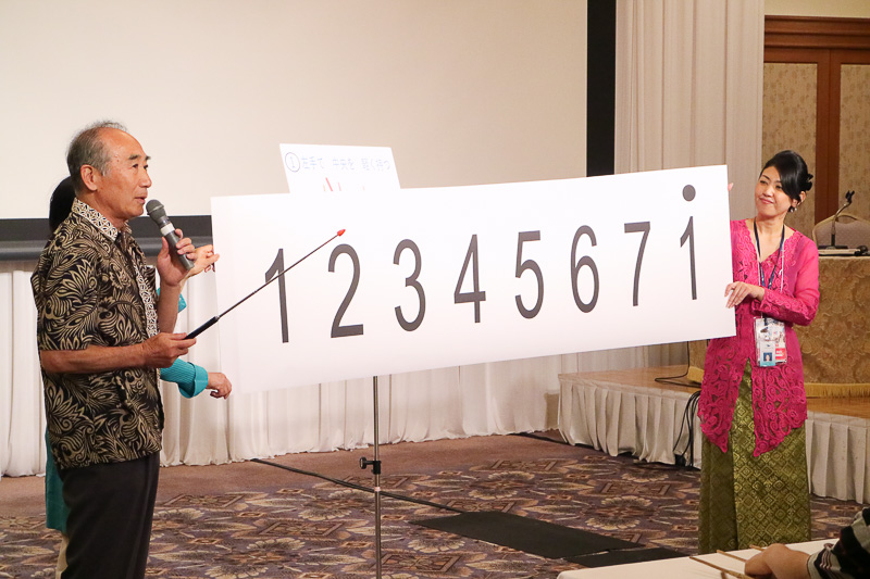 神戸インドネシア友の会 KISアンクルン代表の森井國興氏が、セミナー参加者にアンクルンの演奏を説明