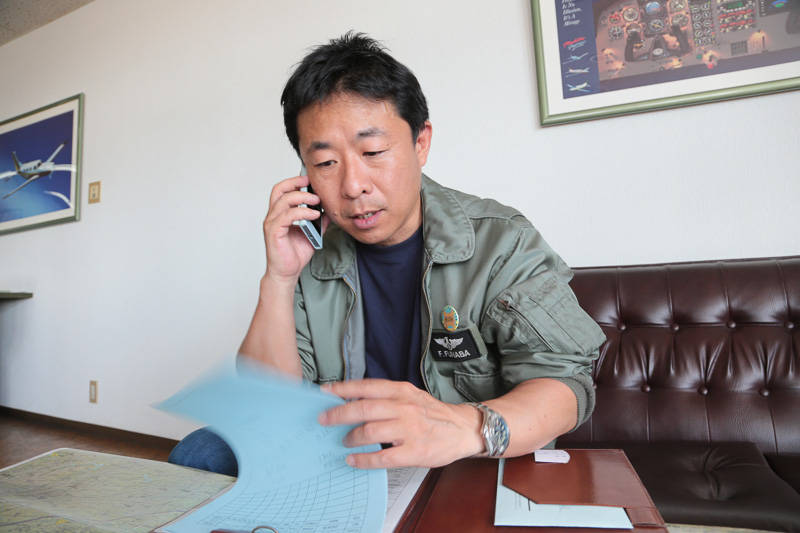 フライトプランを電話で伝える。「（機体のカラーは）ホワイト…ウィズ、キャラクター？」