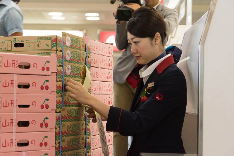 航空貨物として輸送されるさくらんぼの箱に「そら飛ぶさくらんぼ　とれたての美味しさ届けます」のシールを貼付