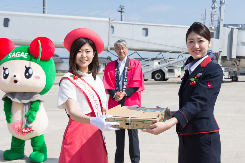 「2017果樹王国ひがしねプリンセス」の直原美沙さんからJALの西田昌司氏へ（写真中央）、「第41代ミスさくらんぼ」の青木瑠美さんから JAL CA（客室乗務員）の上松可奈子氏へ（写真右）、さくらんぼが手渡された