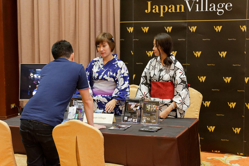 フォーラムに出展しているチェンマイの各施設の代表と真剣に話す参加者たち