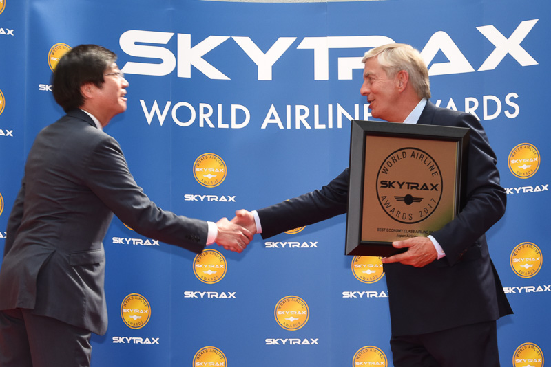 スカイトラックス社長兼CEO エドワード・プレイステッド氏（右）より表彰の盾を受け取る日本航空株式会社 執行役員 路線統括本部国際路線事業本部長の米澤章氏