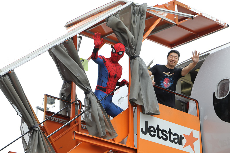 搭乗するスパイダーマンとジェットスター・ジャパン株式会社 代表取締役会長 片岡優氏を見送るバイきんぐ、アベンジャーズの面々