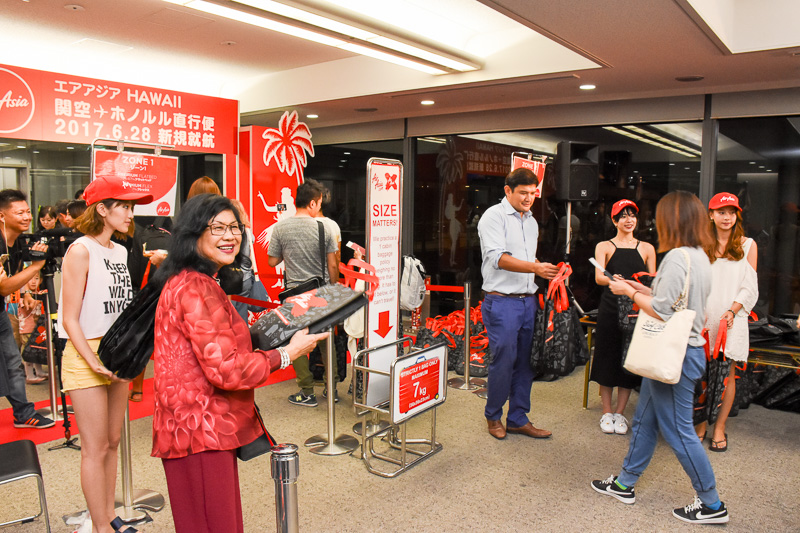 搭乗客に記念品を手渡し、撮影にも応じていた