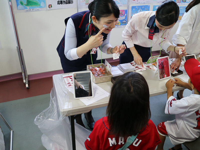 JALや広島東洋カープをモチーフにデザインしたシールを選んで顔に貼ることができる