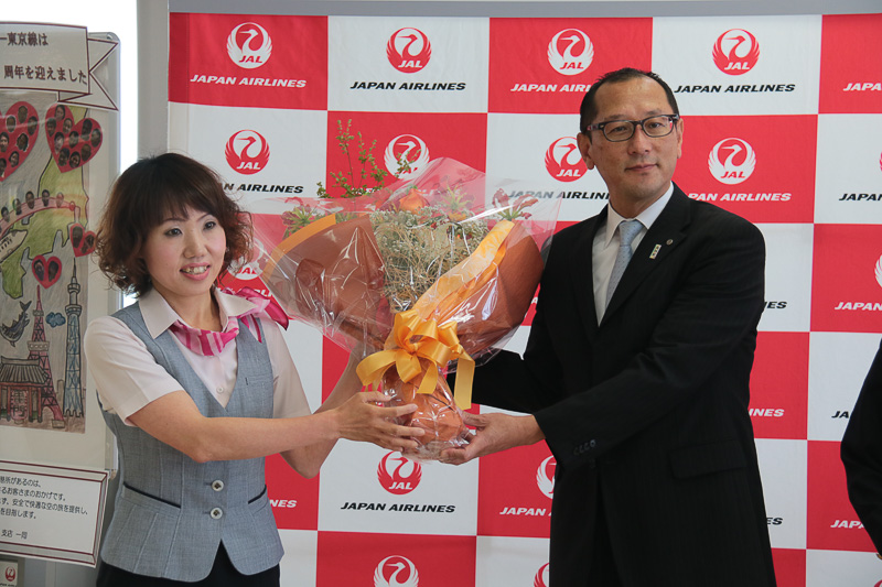 高知空港スタッフから花束を受け取ったJAL 高知支店 支店長 磯村康志氏