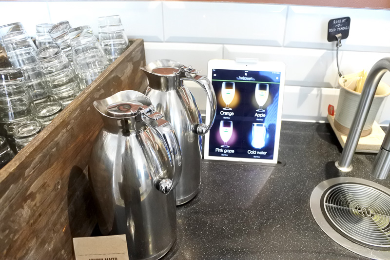 タブレットでドリンクをチョイスし、コップに注ぐ