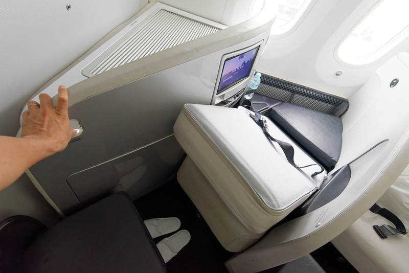 シート右奥、オットマンの近くにはシートをフラットベッドに変形させるボタン。背もたれの裏側が表に返るような形でベッドになる