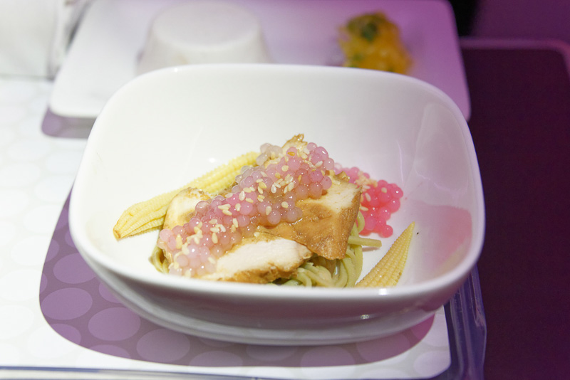 日本時間の21時ごろ、着陸のおよそ1時間半前くらいにディナーとなった。この前菜は中華鹵水（るすい）スープ風味チキンのサラダ。ザクロの実を乗せており、下に茶そばが隠れている