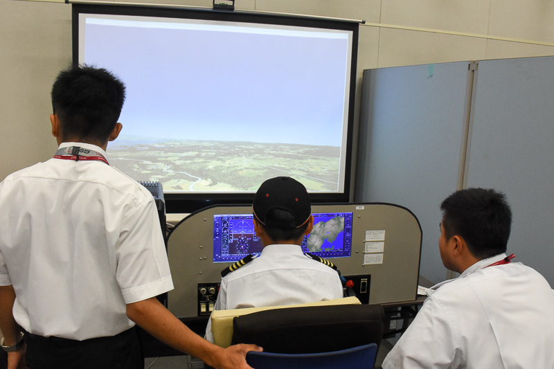 日本航空学園提供のフライトシミュレータの操縦体験。プロジェクタによる大画面で臨場感は抜群。指導官がつきっきりで離陸から着陸までアドバイスを送り、多くの子供がしっかり着陸していた