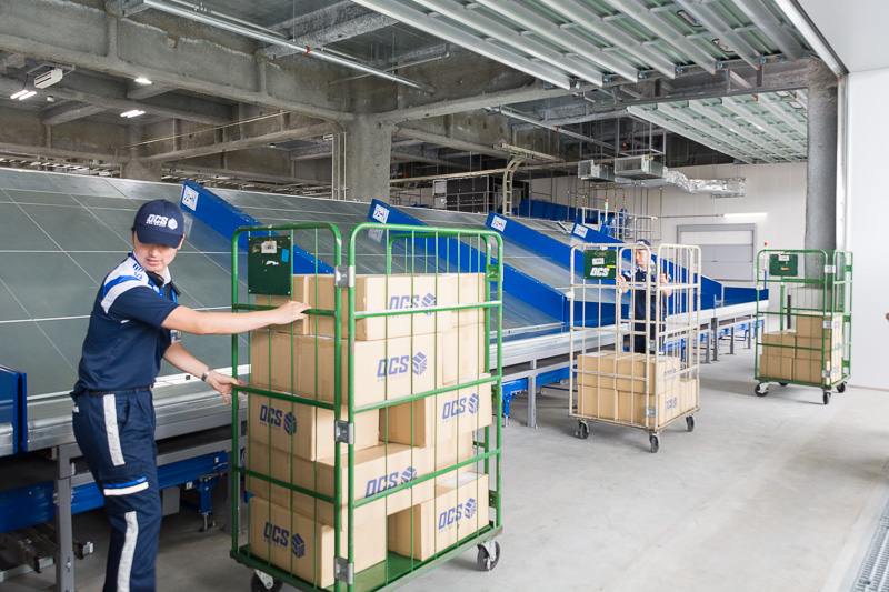 3台目のバーコードリーダーで郵便番号を識別し、行き先別に荷物をシュート。クルーが集配車へ積み込んでいく