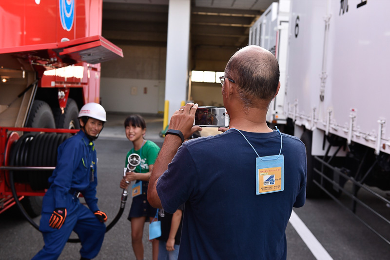 化学消防車のホースを構えてポーズ