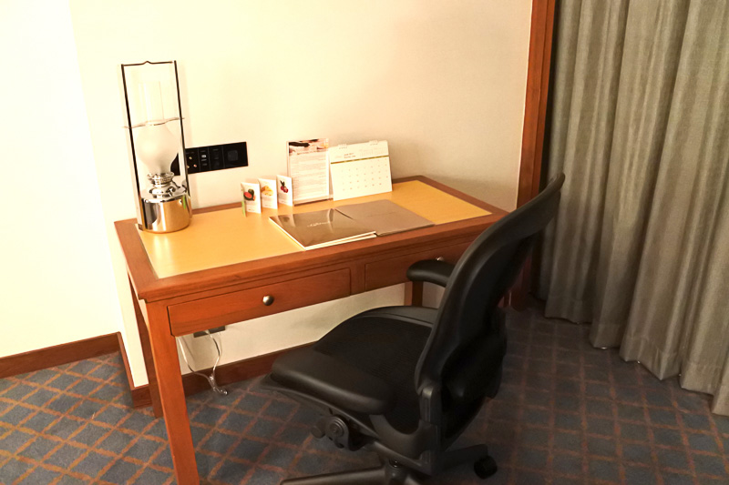 ユニバーサルコンセントやUSBポートなどはデスクの正面の壁側にある