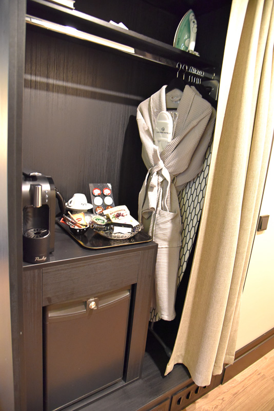 クローゼットにはミニバーと肌触り抜群のガウンとスリッパを用意。アイロン台とアイロンも同じ場所にある