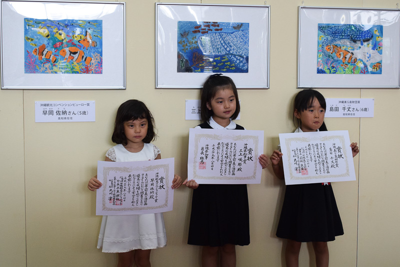 それぞれの作品をバックに、3名揃って記念撮影