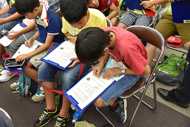 第1回エコツアーを終えて、終了式で田所氏の話を聞くエコキッズ・クラブのメンバー。終了後は感想をアンケートに記入した